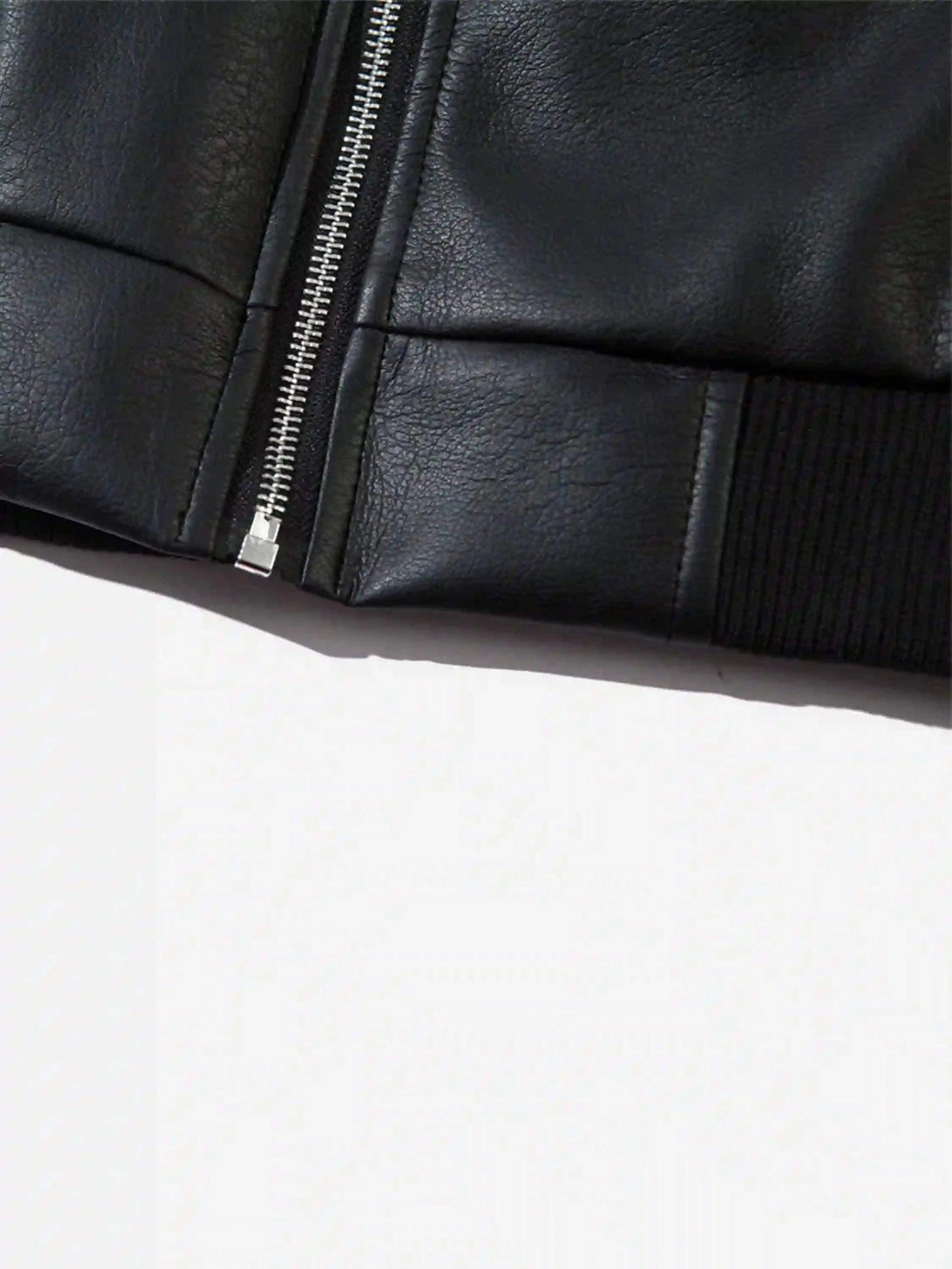 A zoomed-in view of TALISHKO's black leather motorcycle jacket showcasing sleek zipper detail.