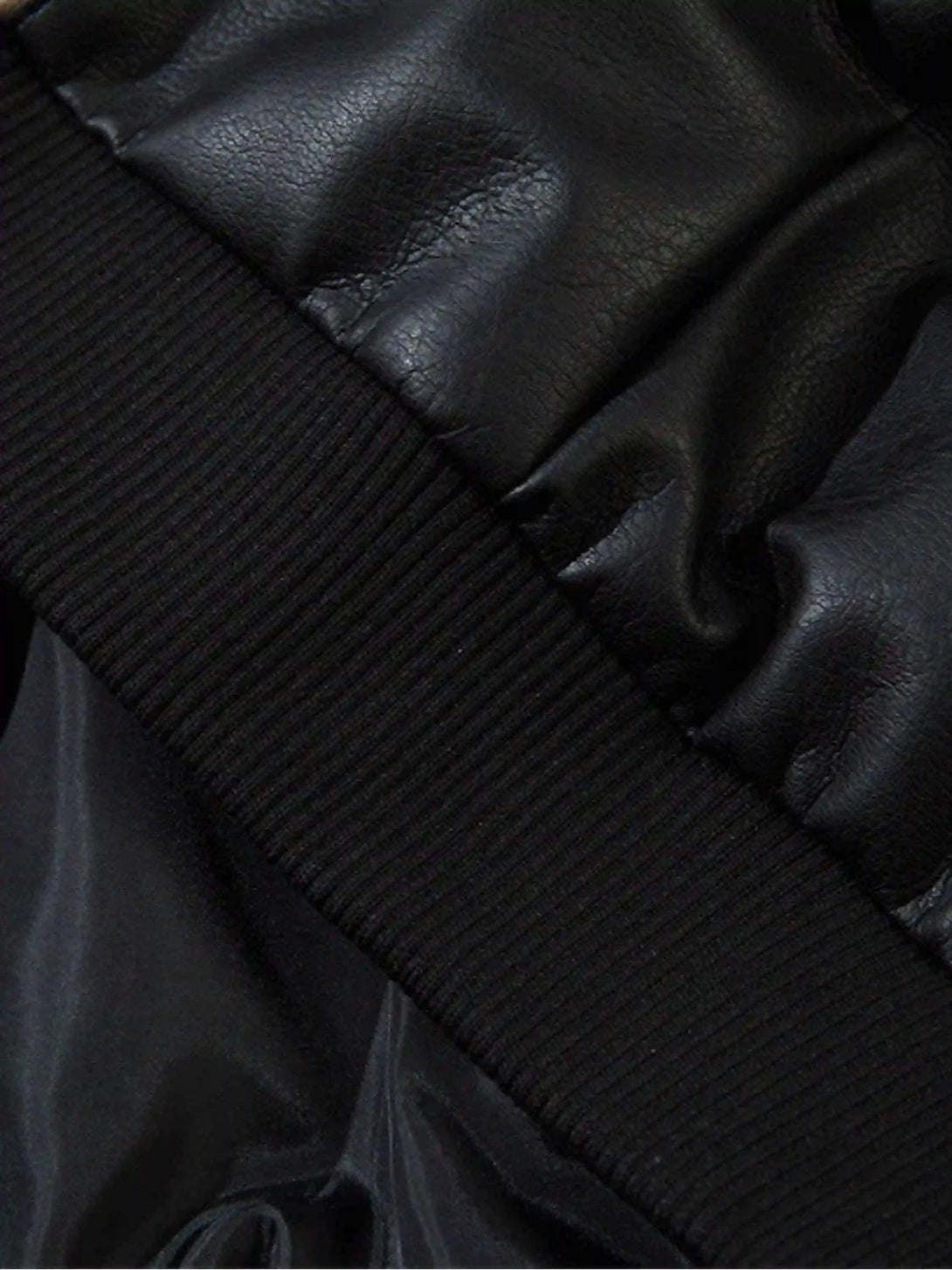 A close-up of TALISHKO's black leather motorcycle jacket highlighting ribbed cuff details.