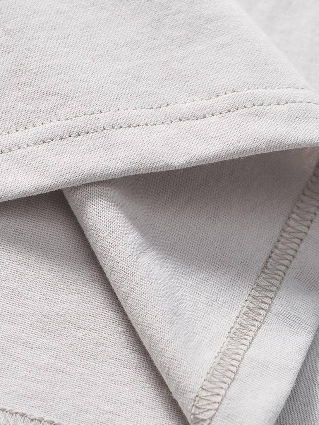 Detailed fabric and stitching of TALISHKO's patchwork T-shirt, highlighting quality craftsmanship.