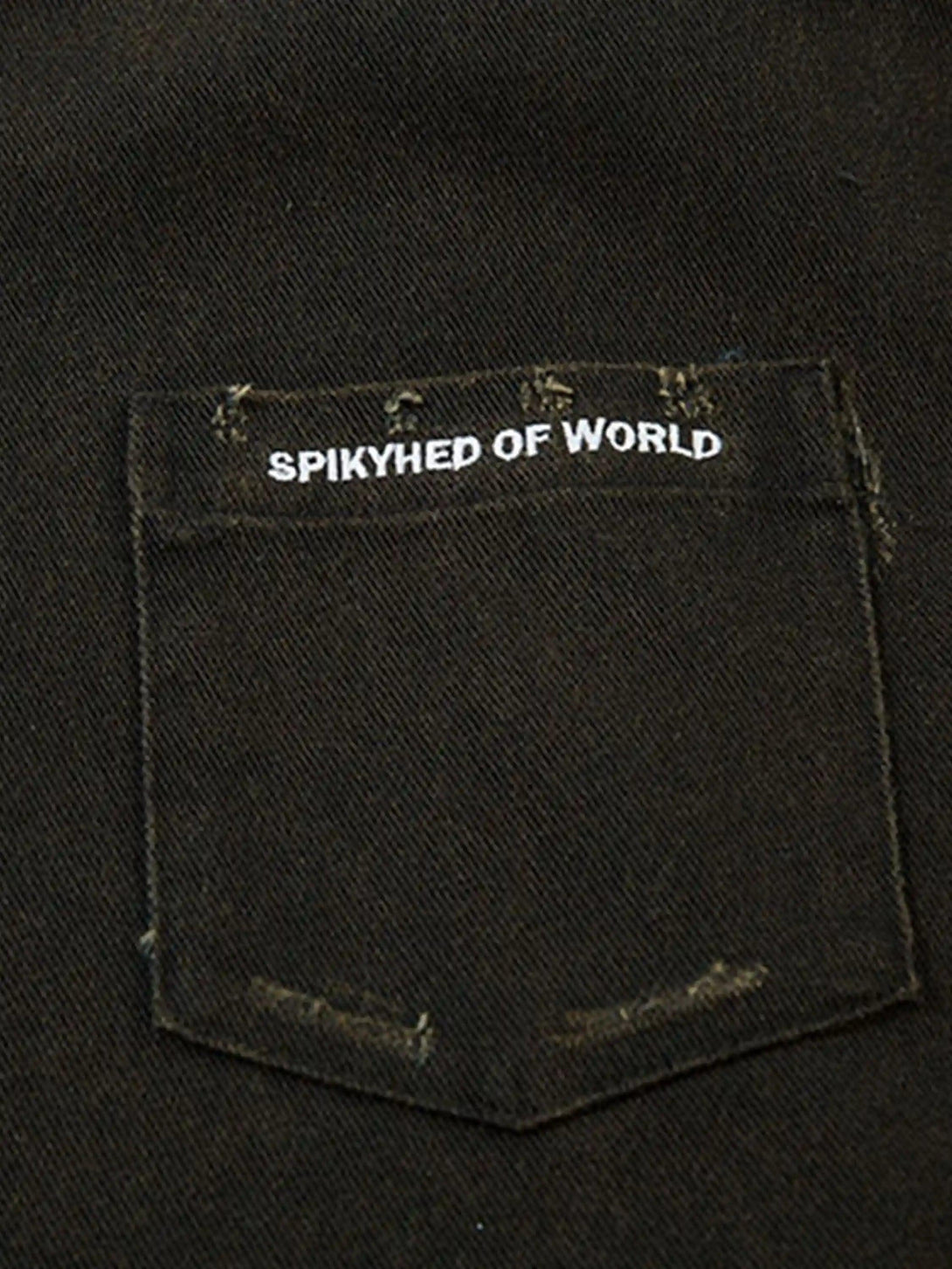 Focusing on the pocket detail of TALISHKO's shirt, highlighting its raw edge design.