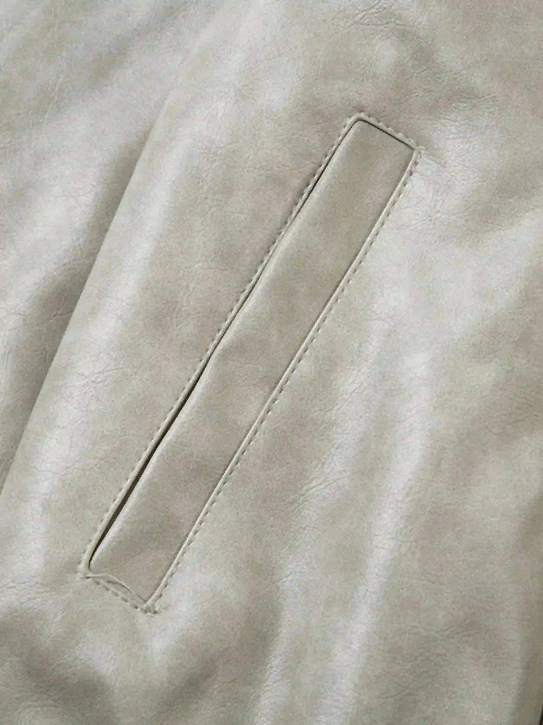 A detailed view of TALISHKO's motorcycle jacket pocket, showcasing its sleek design and texture.