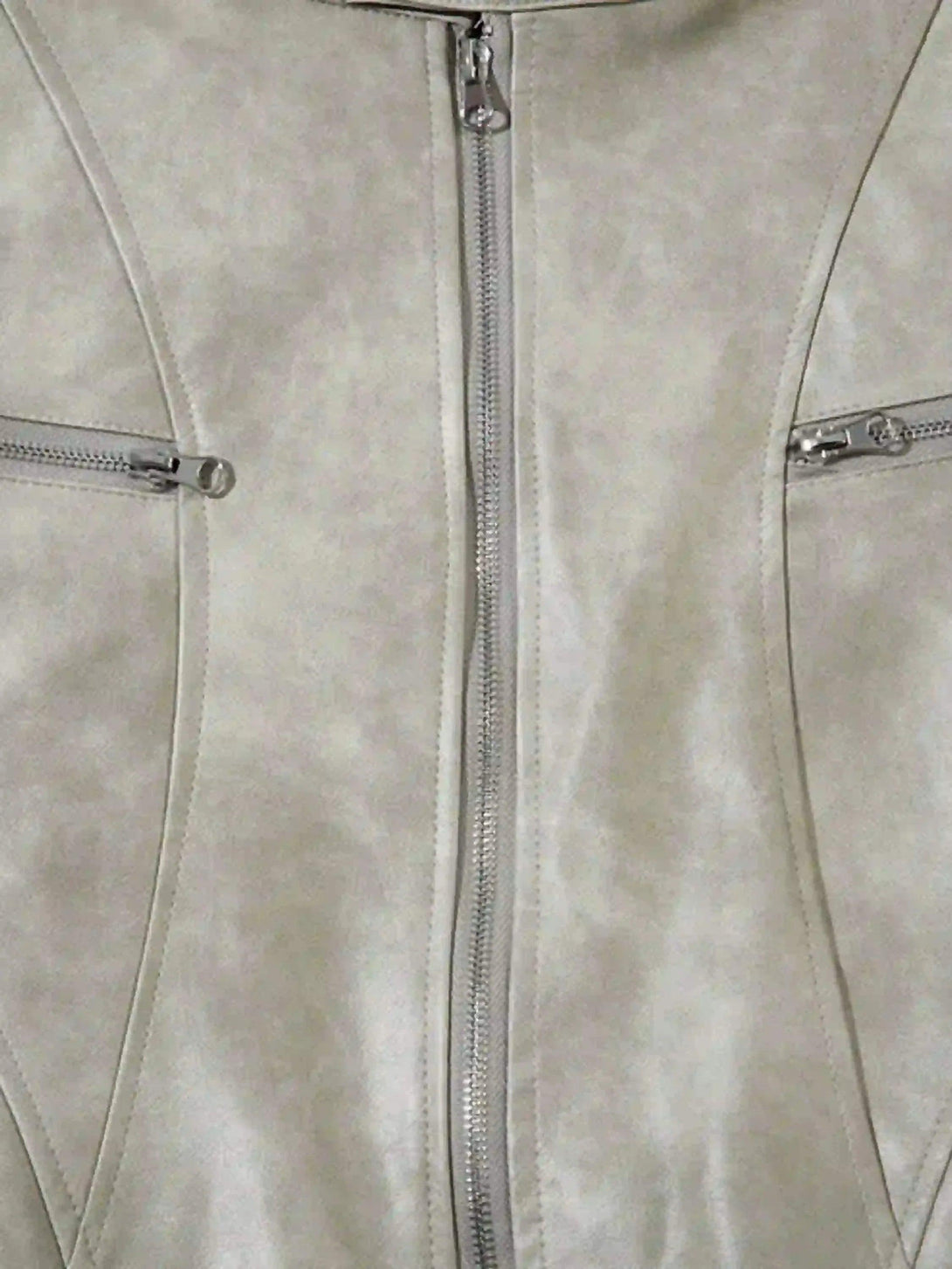 Detailed view of TALISHKO motorcycle jacket's front zippers and stitching on soft fabric.