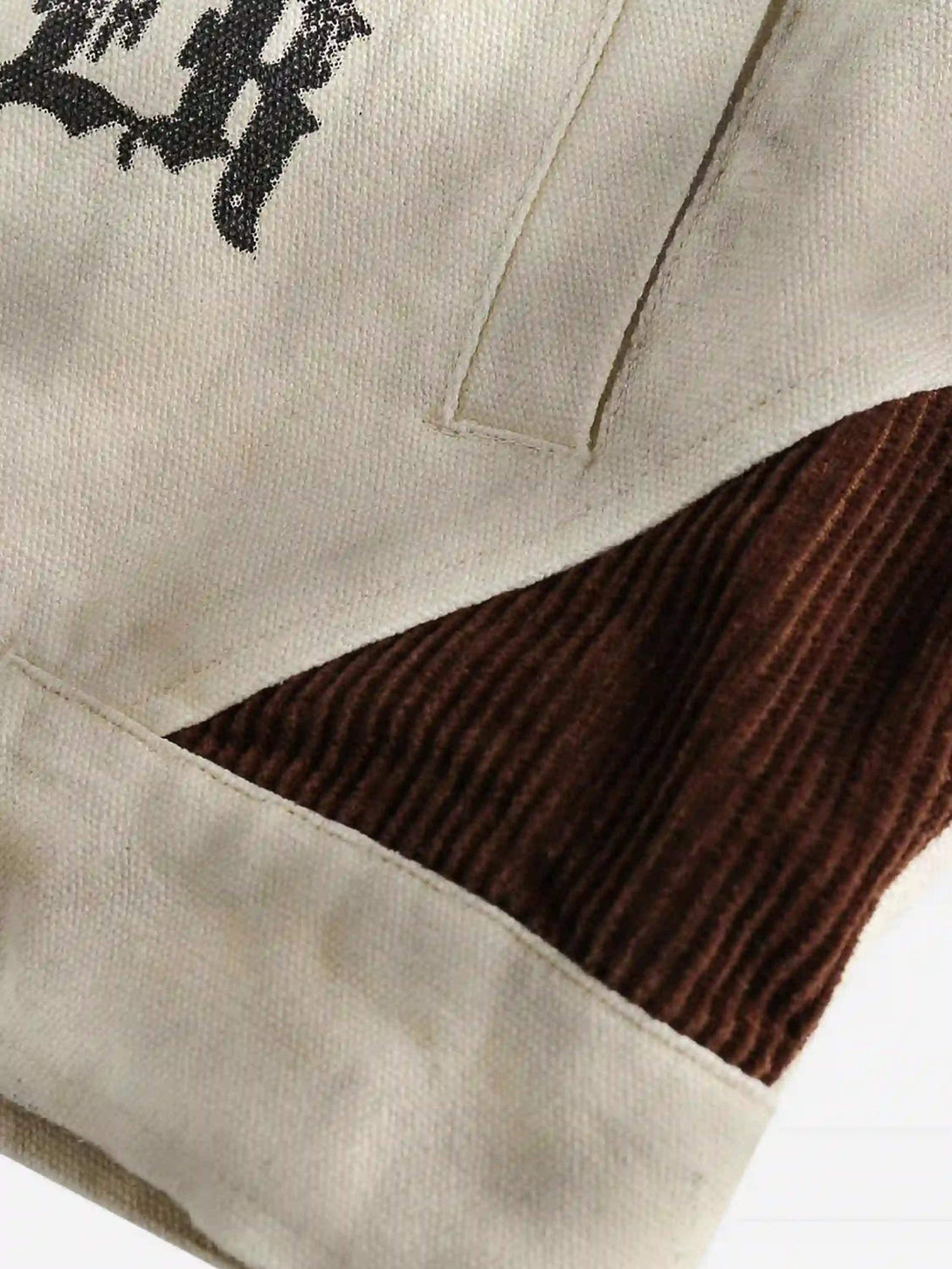 A close-up of the TALISHKO patchwork jacket, highlighting textured fabric and brown detailing.