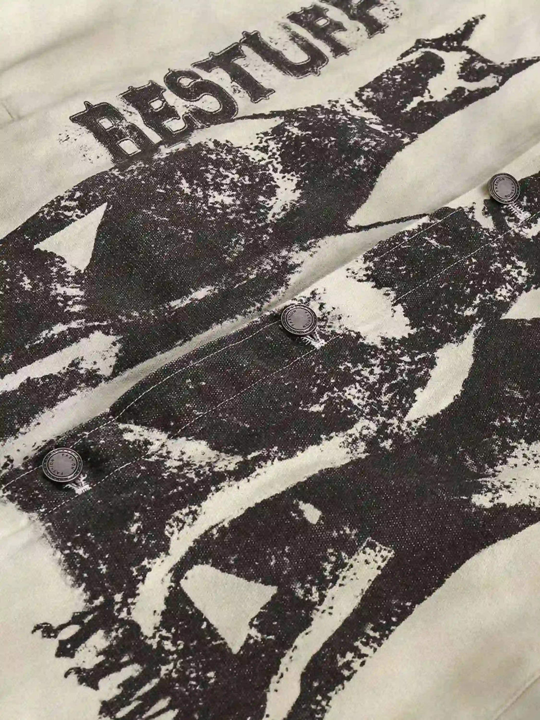 A detailed view of the TALISHKO jacket, highlighting graffiti print and button details.