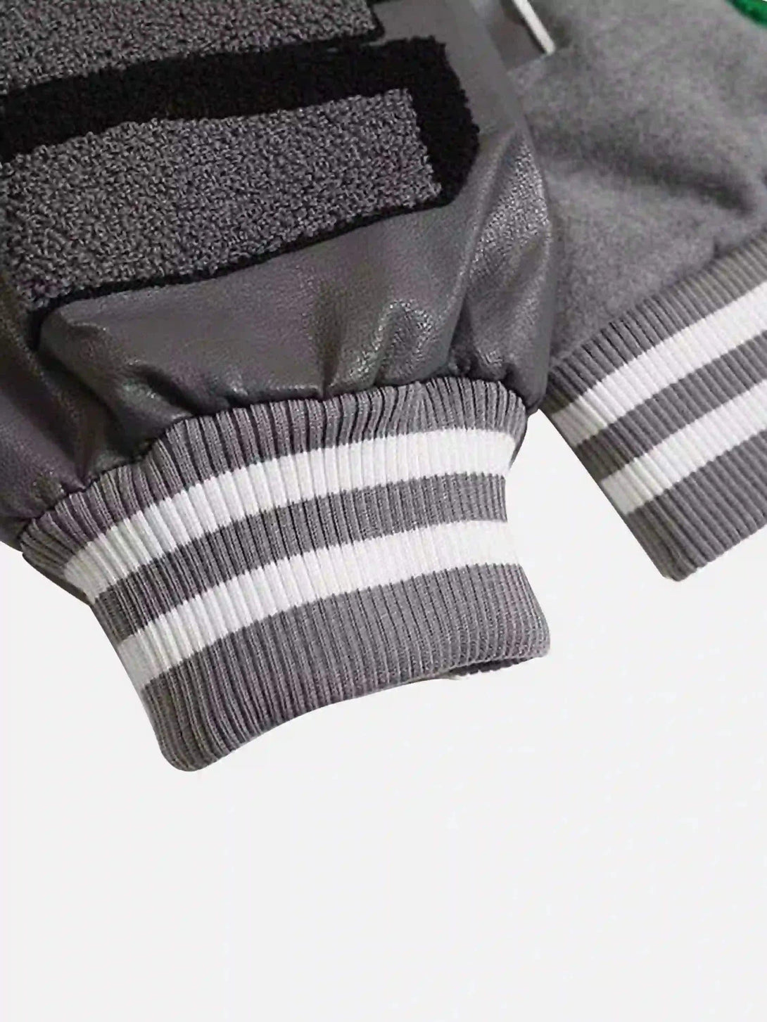 A close-up of TALISHKO's woolen baseball jacket cuff detailing in gray and white stripes.