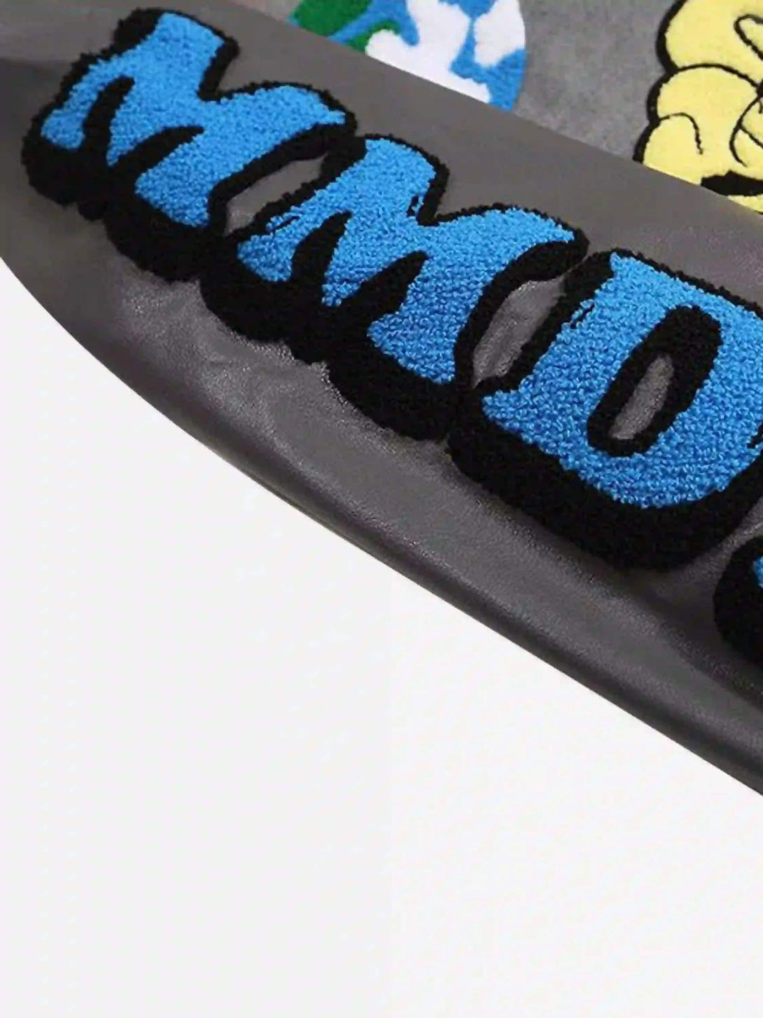 Detailed texture of TALISHKO's woolen baseball jacket showcasing vibrant blue lettering.