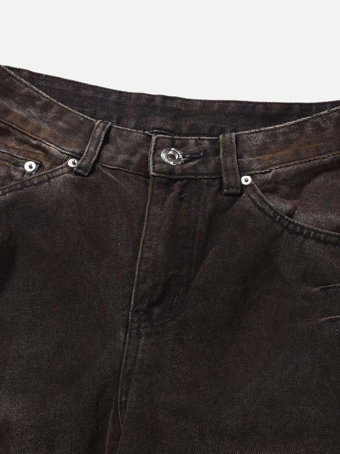 A detailed view of TALISHKO's heavy industry washed jeans, highlighting rugged texture and stitch.