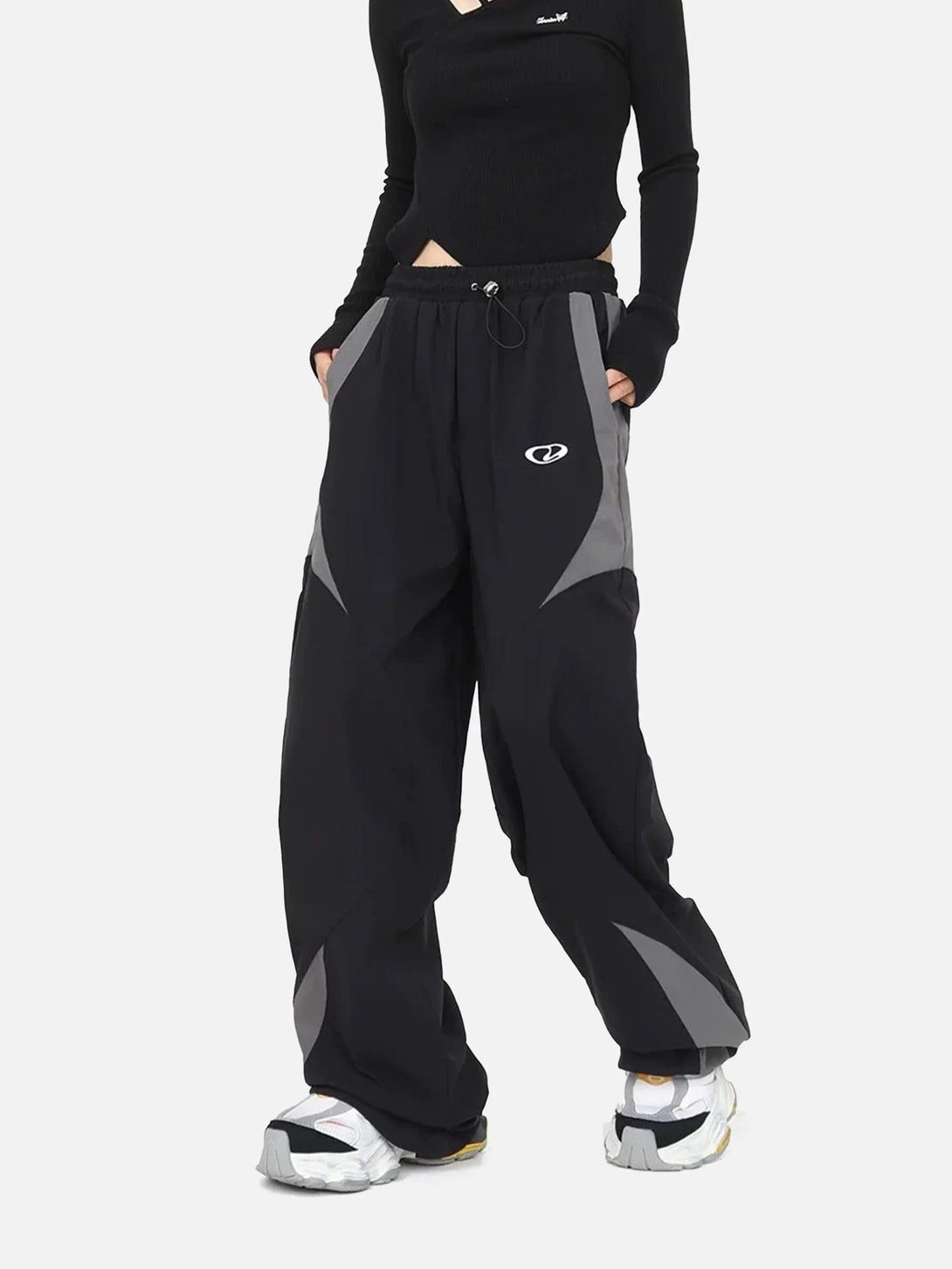 TALISHKO splicing design sports pants in black and gray, worn by model, highlight street style.