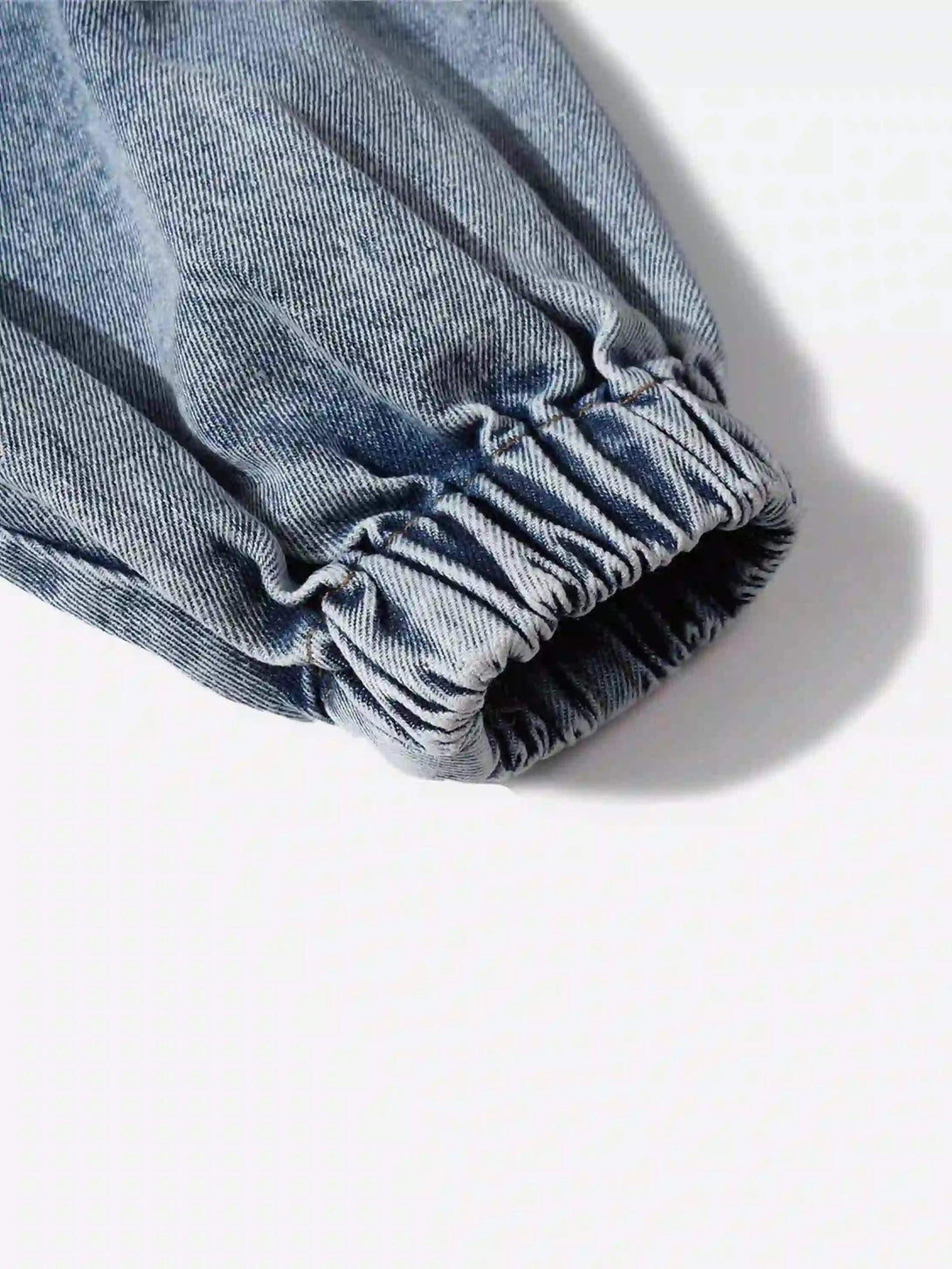 Detailed view of TALISHKO's denim hoodie sleeve, highlighting elastic cuff and fabric texture.
