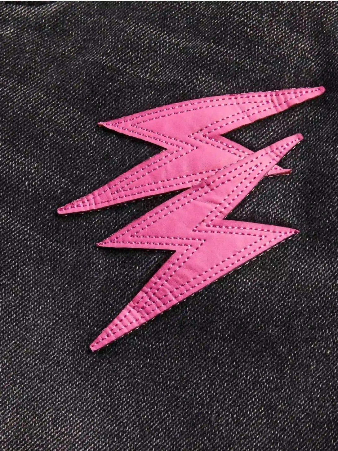 Pink lightning bolt detail on TALISHKO jeans, highlighting bold design and street style flair.