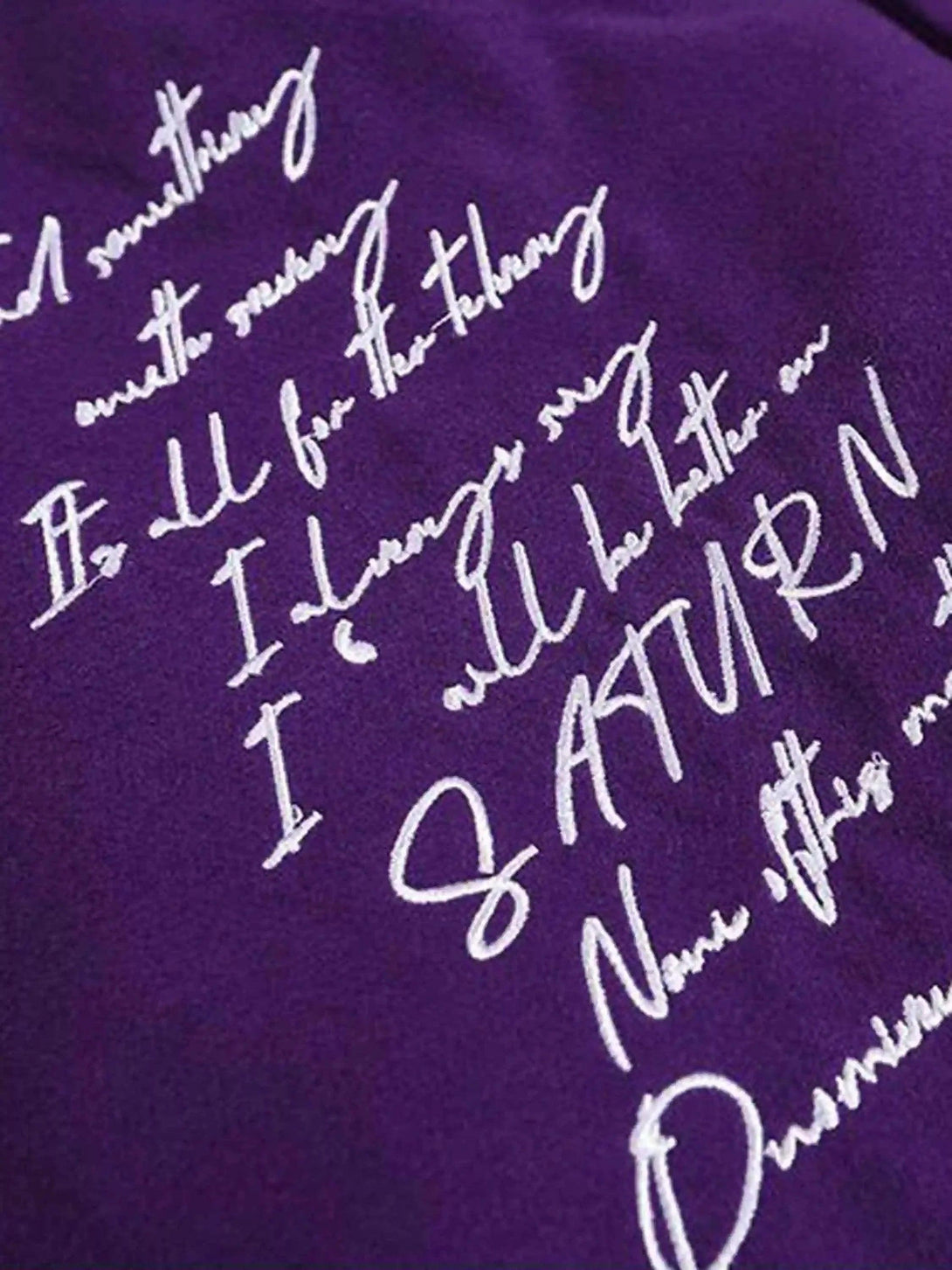 Detailed fabric and stitching on the purple TALISHKO baseball jacket showcasing embroidery.