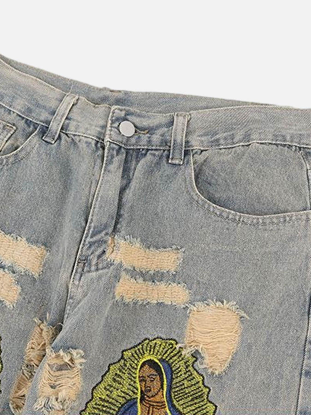 Close-up of TALISHKO's distressed denim with detailed religious patchwork design.