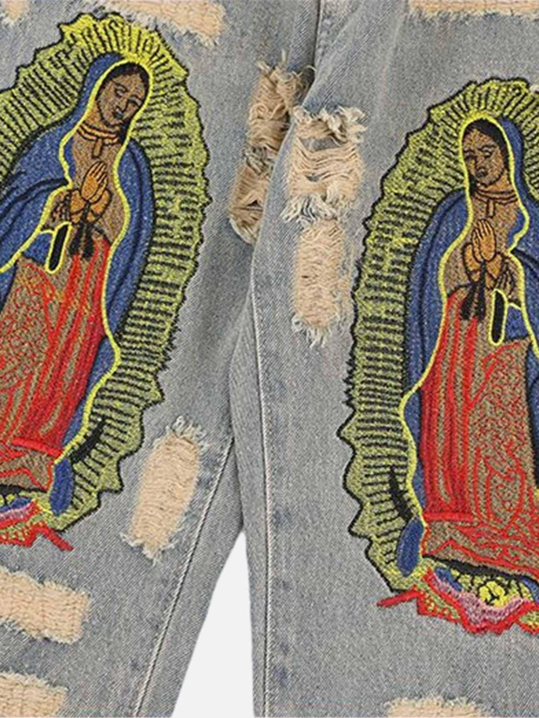 Intricate religious patch detail on TALISHKO's ripped denim, highlighting unique street style.