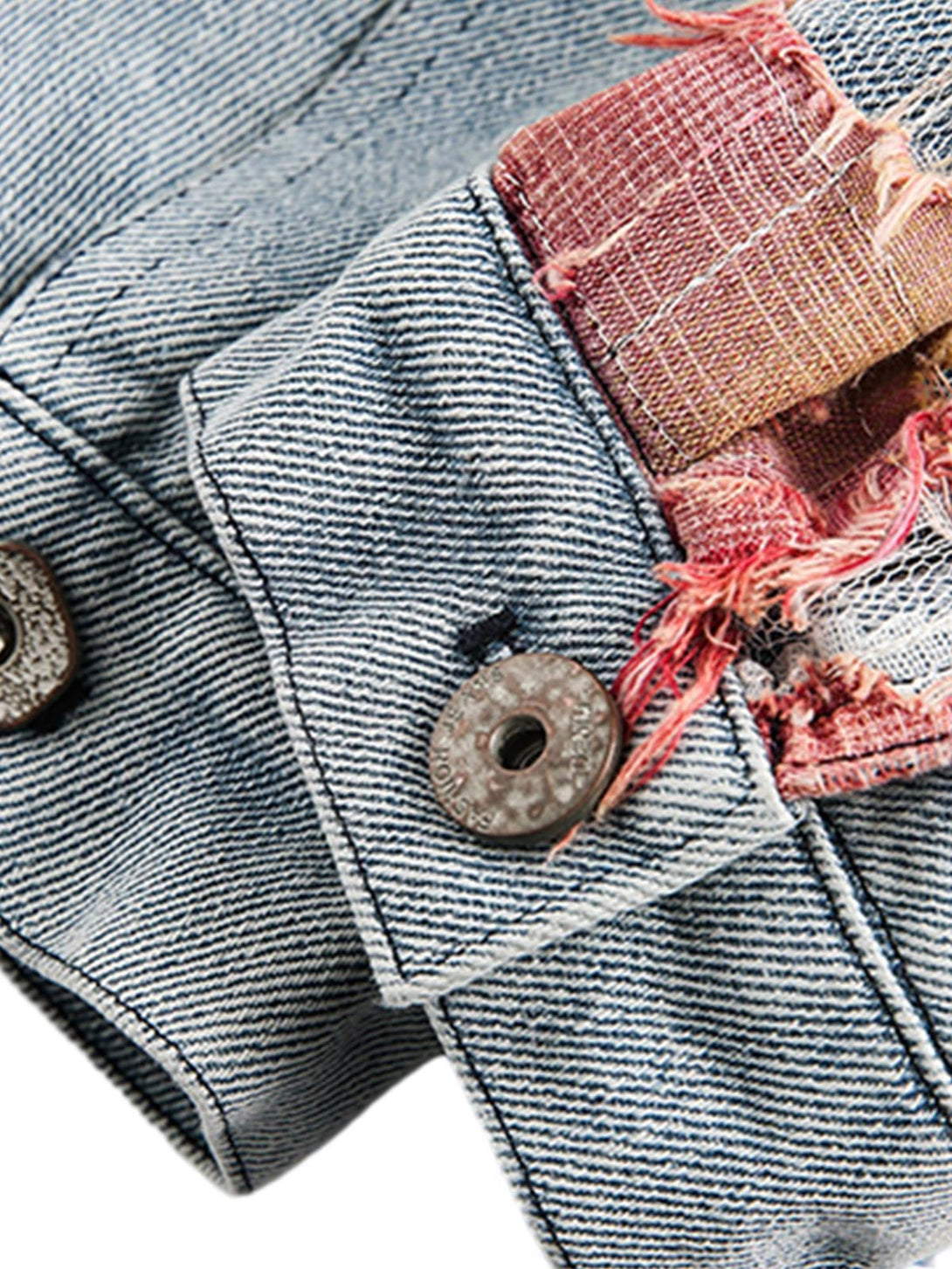 A detailed view of TALISHKO denim jacket's button and lace patchwork, highlighting unique design.