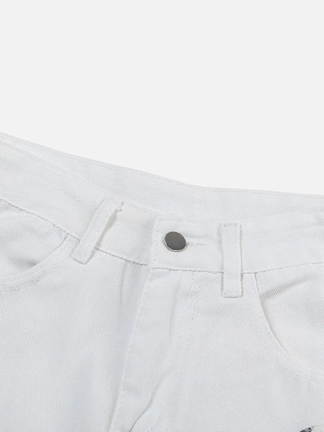 Focusing on the waistband detail of TALISHKO's white patch jeans, highlighting street style.