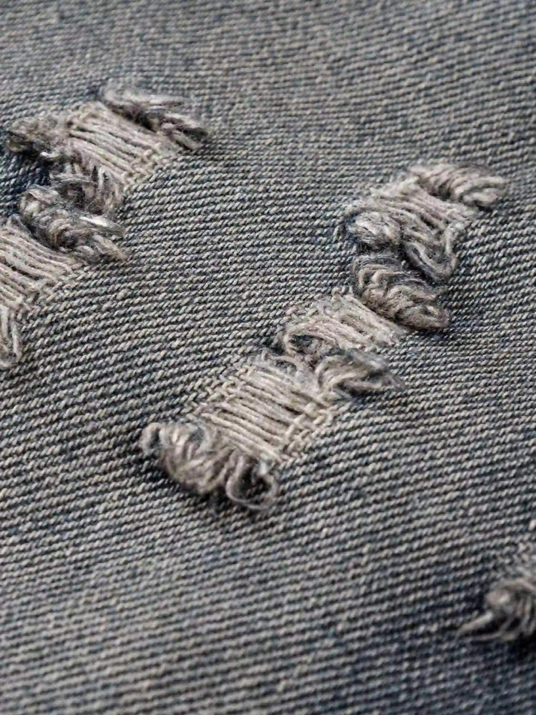 Intricate look at the distressed denim texture on a TALISHKO retro hoodie.