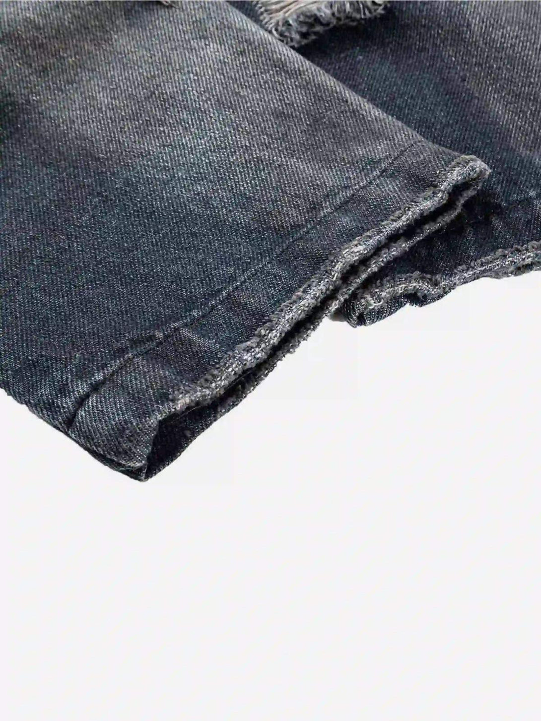 A detailed look at the distressed hem of a retro hoodie by TALISHKO, highlighting texture.