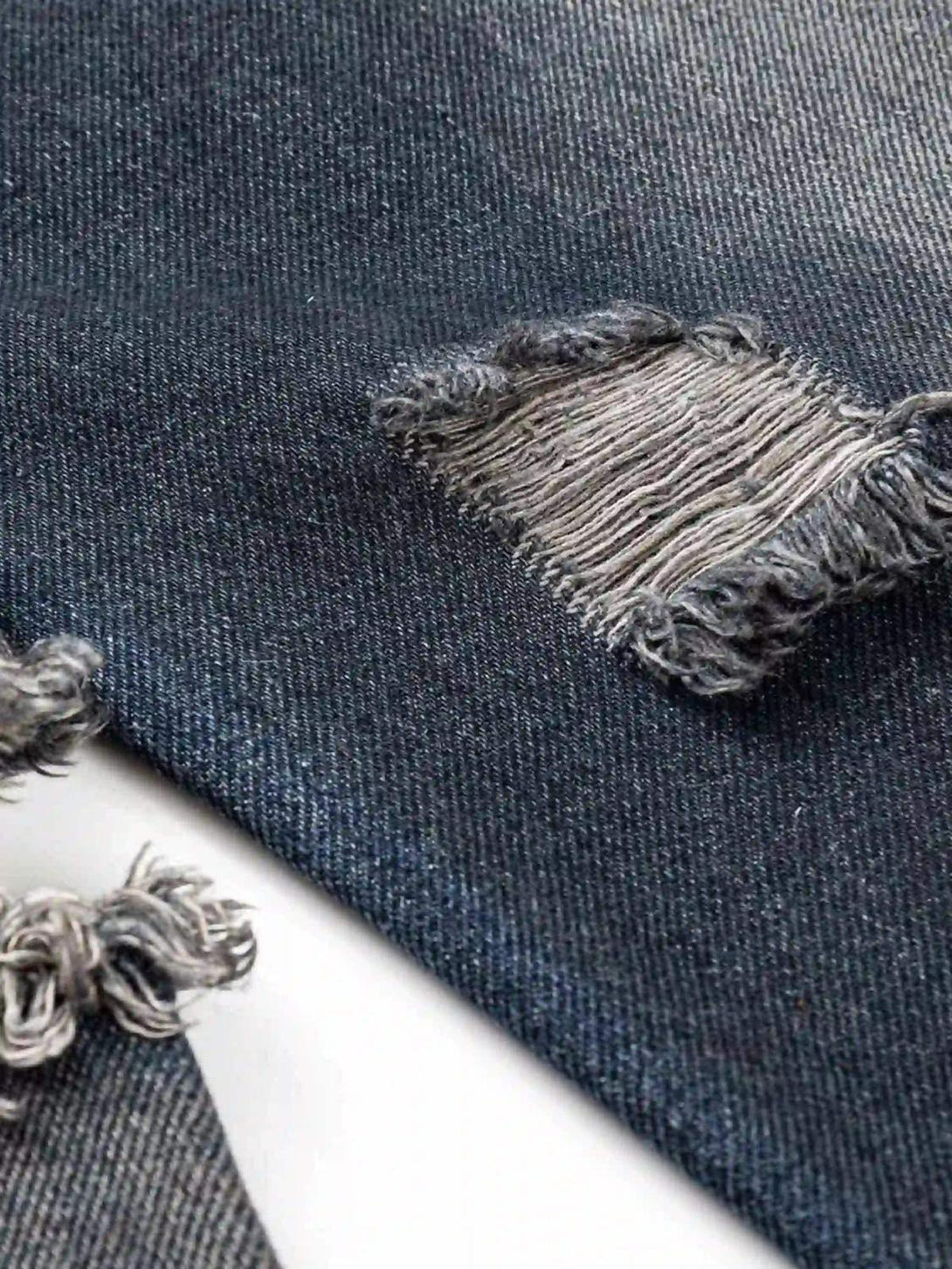 A detailed view of the distressed denim texture on a TALISHKO retro street-style hoodie.