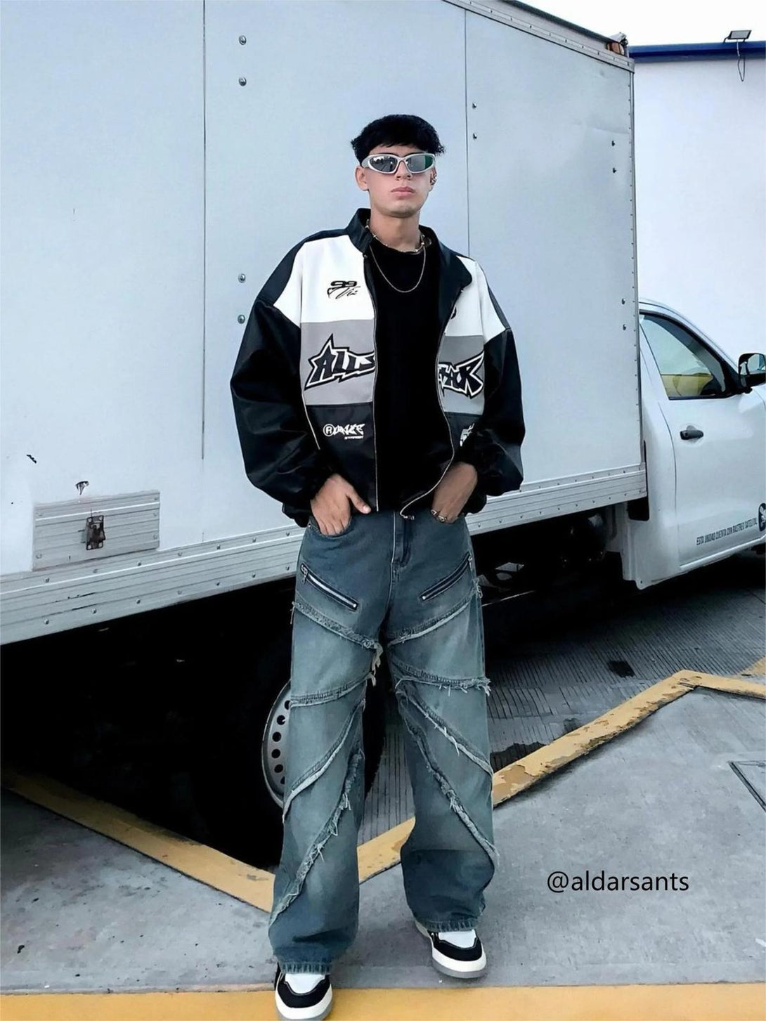 Model wearing TALISHKO street style distressed jeans with a black and white jacket.