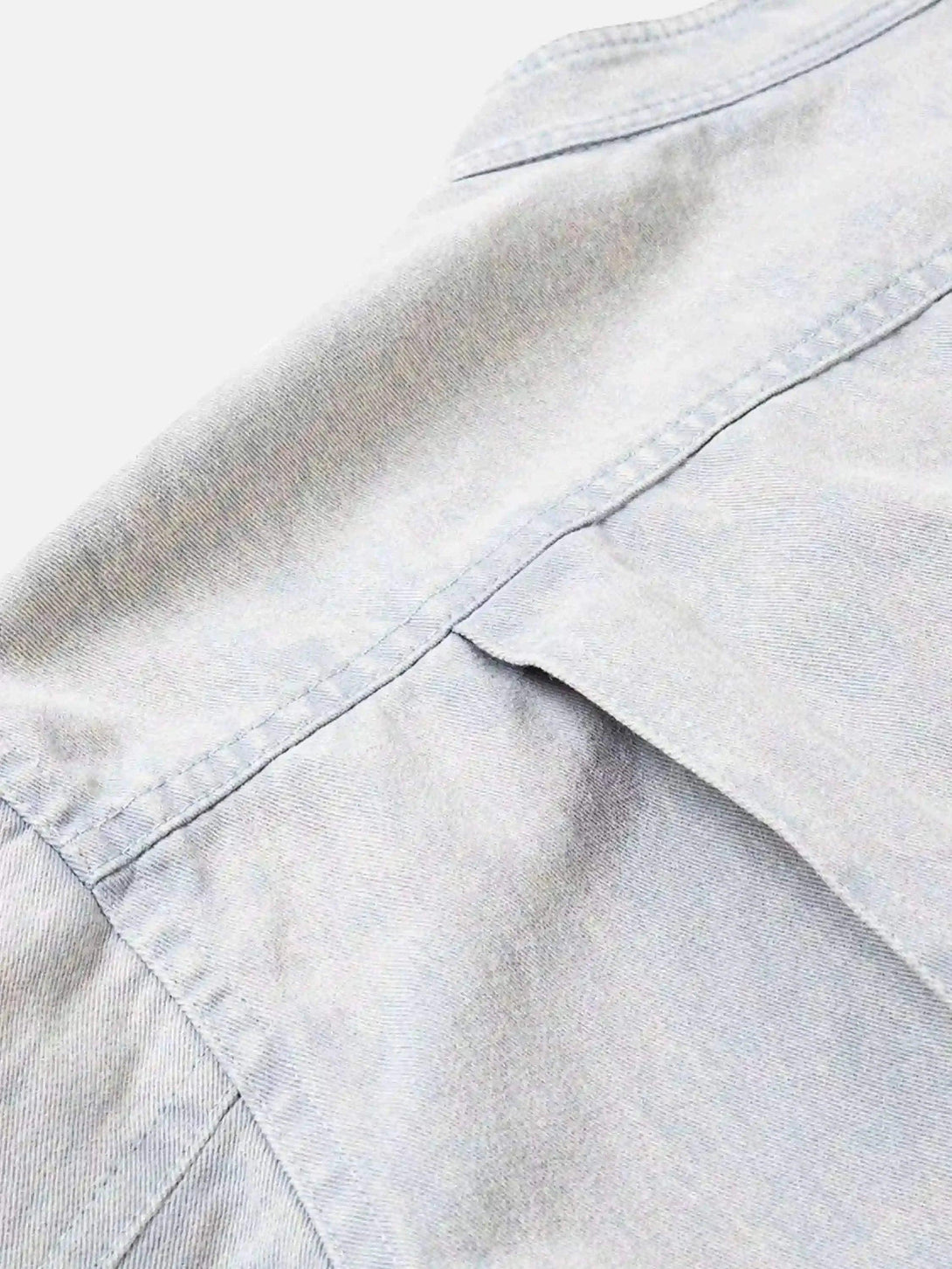 A detailed view of the stitching on TALISHKO's washed faded short jacket, highlighting craftsmanship.