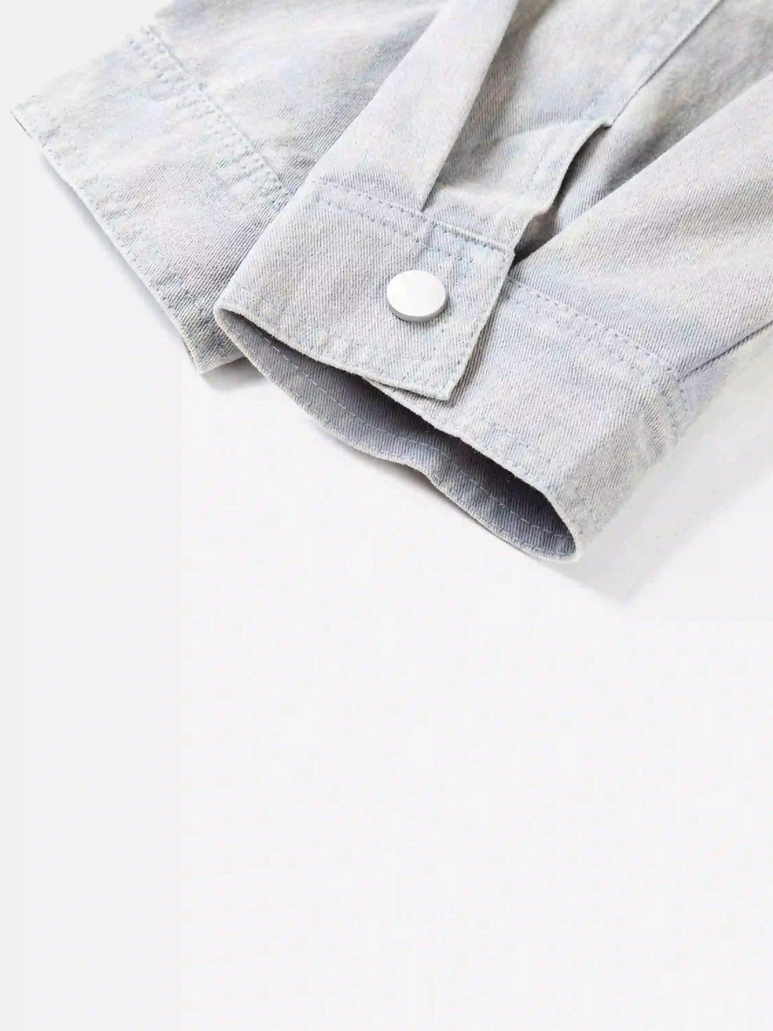 Close-up of the cuff and button detail on TALISHKO's washed faded short jacket.