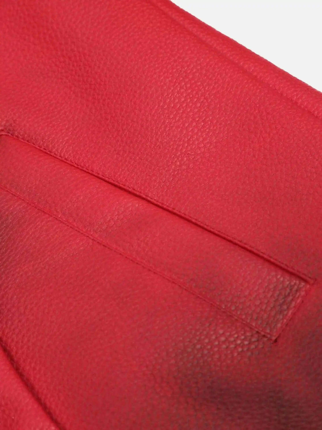 A detailed view of the red leather texture on a TALISHKO motorcycle jacket.