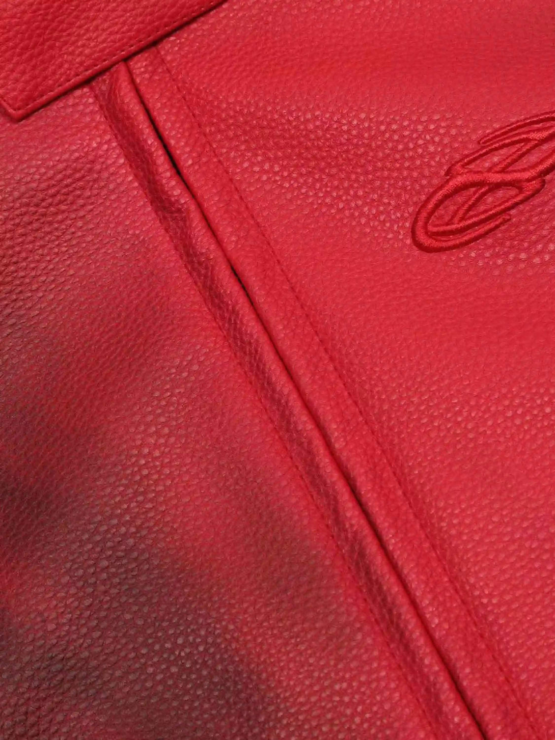Focusing on the rich red leather texture and embroidery detail of a TALISHKO motorcycle jacket.