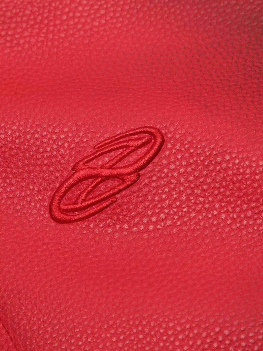 Intricate look at the 3D embroidery on TALISHKO's red motorcycle jacket, highlighting texture.