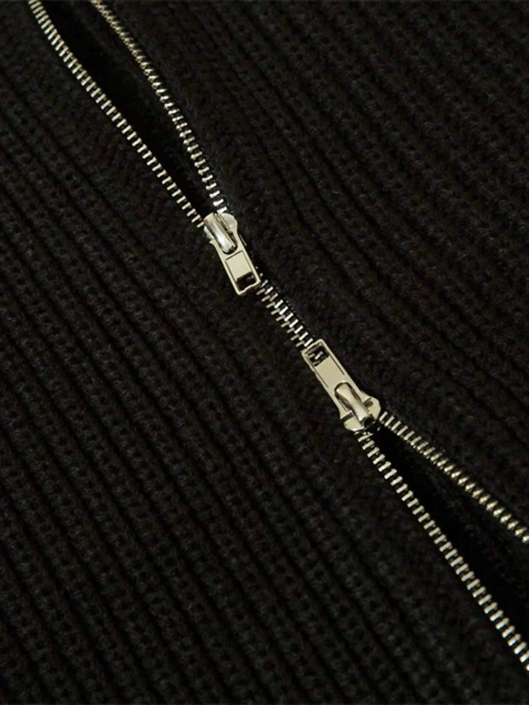 A detailed look at TALISHKO's cardigan zipper, highlighting the ribbed knit texture.