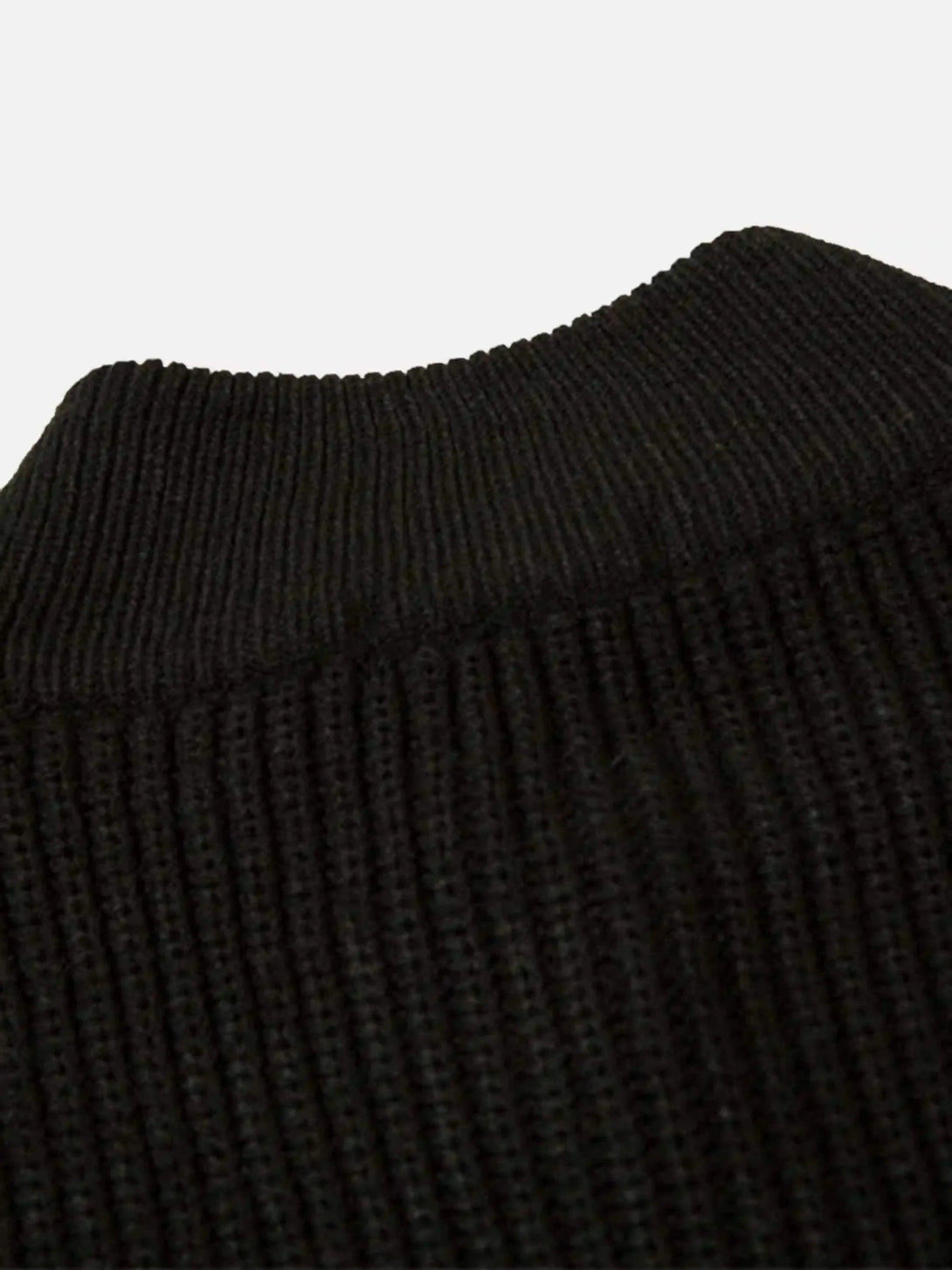 Detailed fabric and stitching on TALISHKO's black cardigan, showcasing ribbed texture.