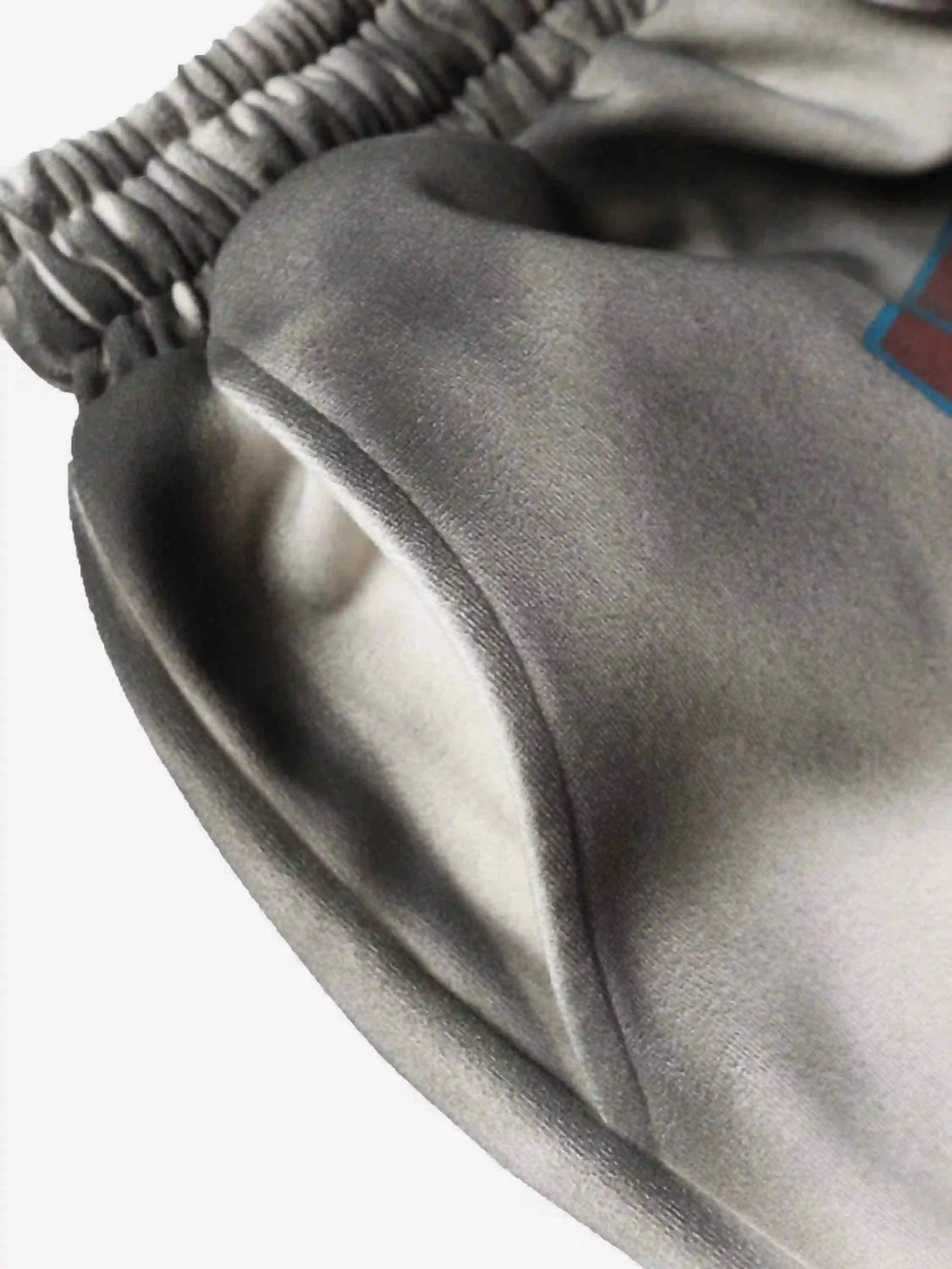 Intricate look at TALISHKO's elastic waistband on gradient print shorts, highlighting texture.