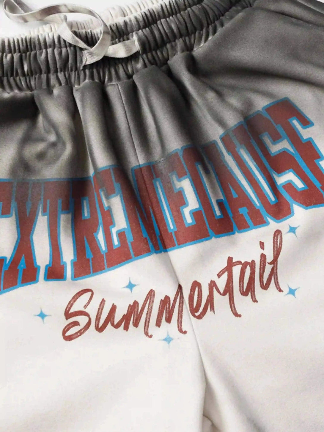 Elastic waistband and graphic text detail on TALISHKO's gradient print shorts for a casual vibe.