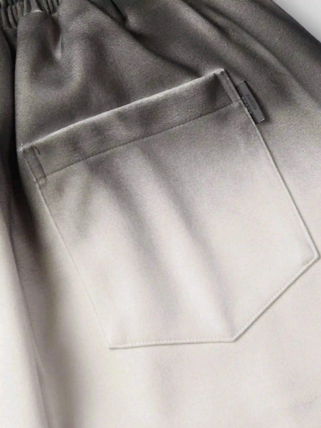 Focusing on the pocket detail of TALISHKO's gradient print shorts, highlighting the fabric texture.