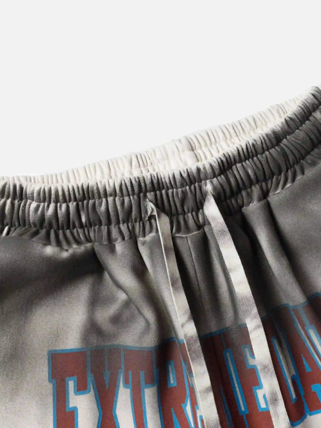 Elastic waistband detail of TALISHKO gradient print shorts with "Extreme" graphic text.