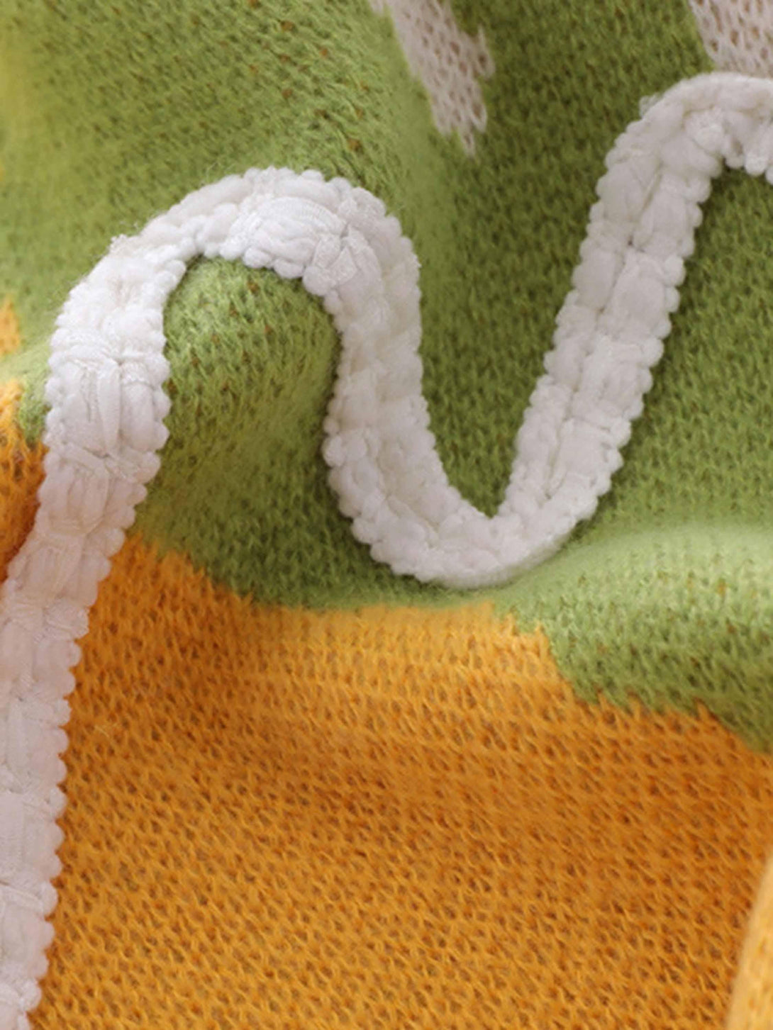 A detailed look at the knit texture of a colorful sweater vest by TALISHKO.