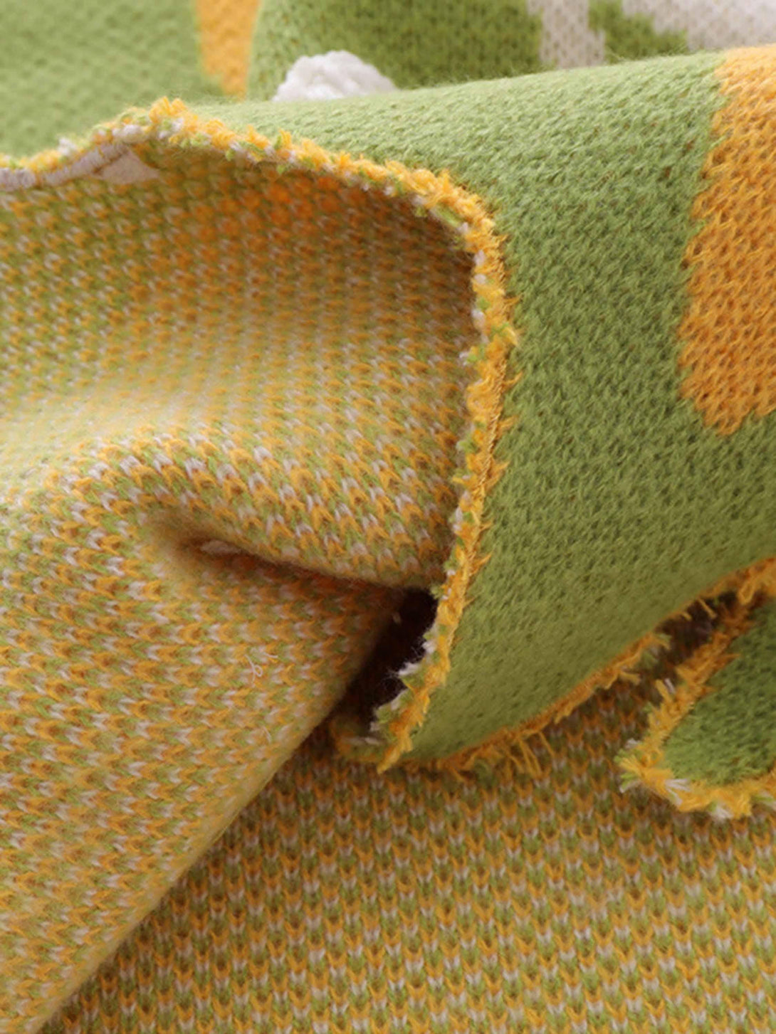 Zoomed-in texture of a colorful sweater vest by TALISHKO, highlighting its intricate knit.