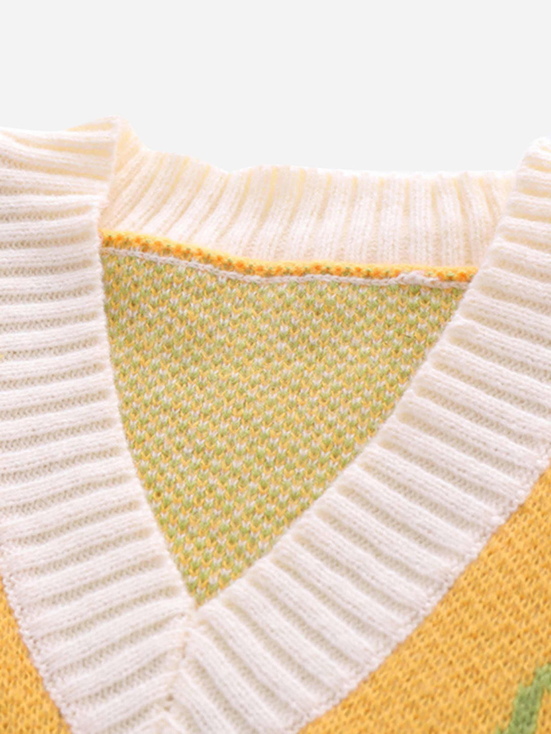 Detailed look at a yellow sweater vest by TALISHKO, showcasing intricate knit texture.