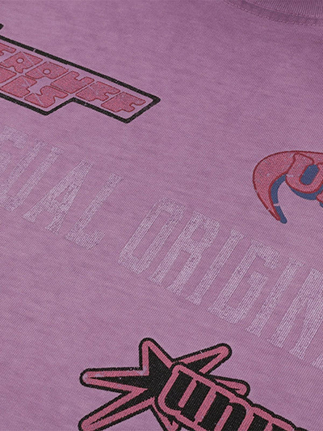 Zoomed-in texture of a purple T-shirt featuring playful sticker patterns by TALISHKO.