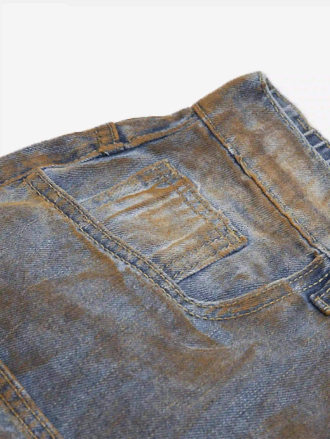 Intricate look at the worn texture and stitching of TALISHKO's wide-leg denim jorts.
