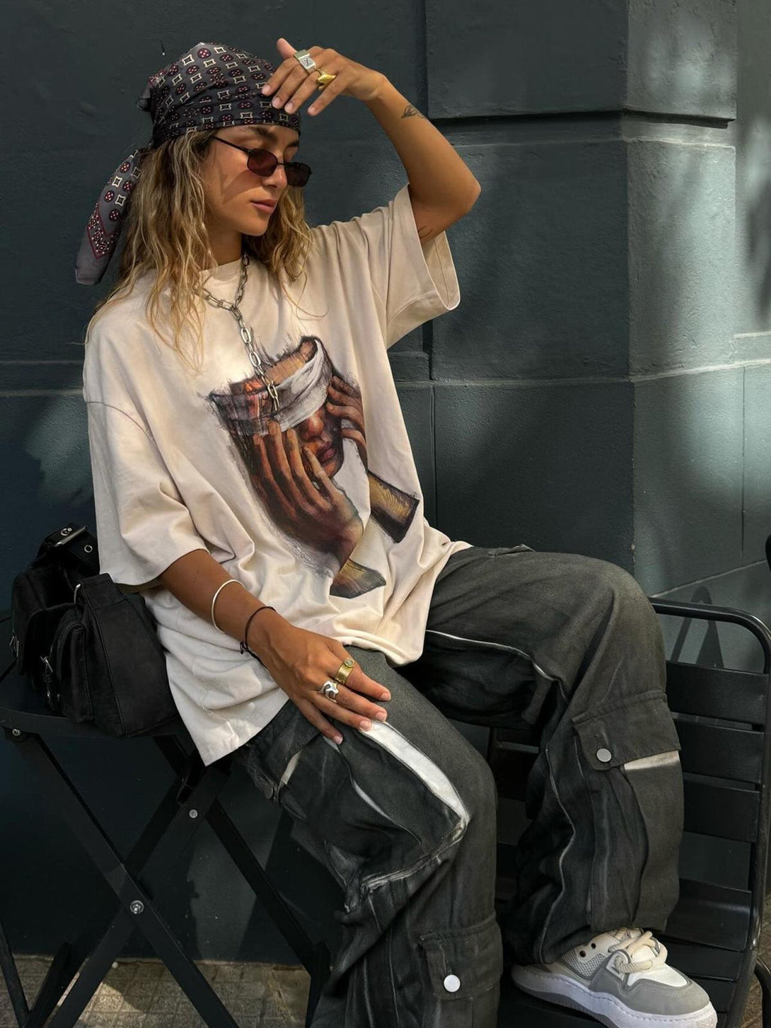 Street style with TALISHKO's loose print T-shirt and cargo pants, paired with stylish accessories.