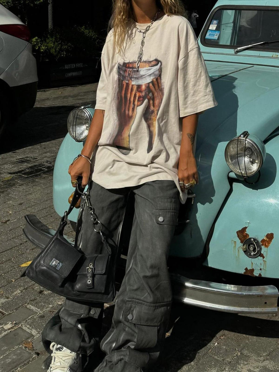 Casual street vibe with TALISHKO's loose print T-shirt and cargo pants against a vintage car.