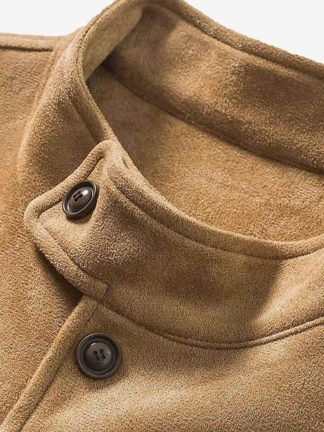 Intricate look at the collar and button detail of a brown patchwork jacket by TALISHKO.