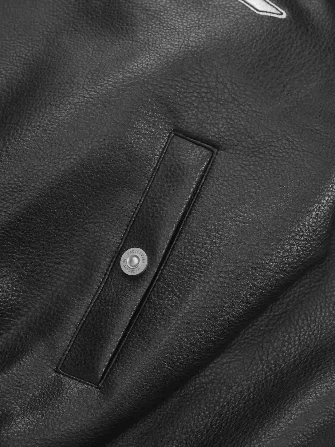 A detailed view of TALISHKO's PU leather jacket pocket, highlighting texture and craftsmanship.