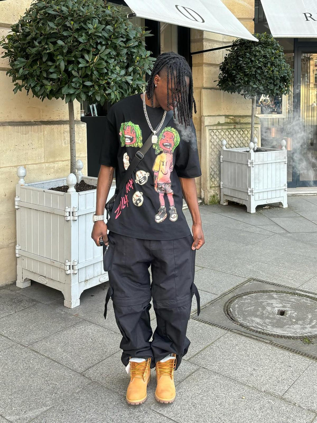 A trendy outfit featuring a TALISHKO anime character T-shirt, paired with black cargo pants and boots.