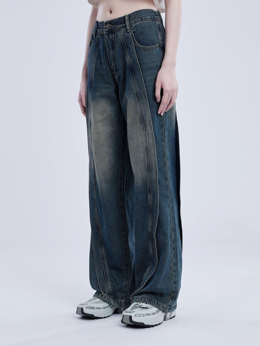 Model in TALISHKO arc patchwork jeans, emphasizing the relaxed fit and detailed stitching.