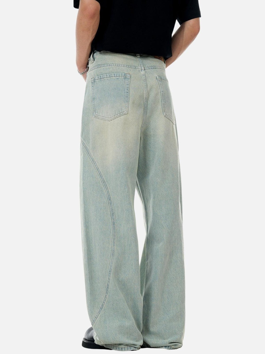 Back view of TALISHKO loose jeans with arc patchwork, highlighting relaxed streetwear style.