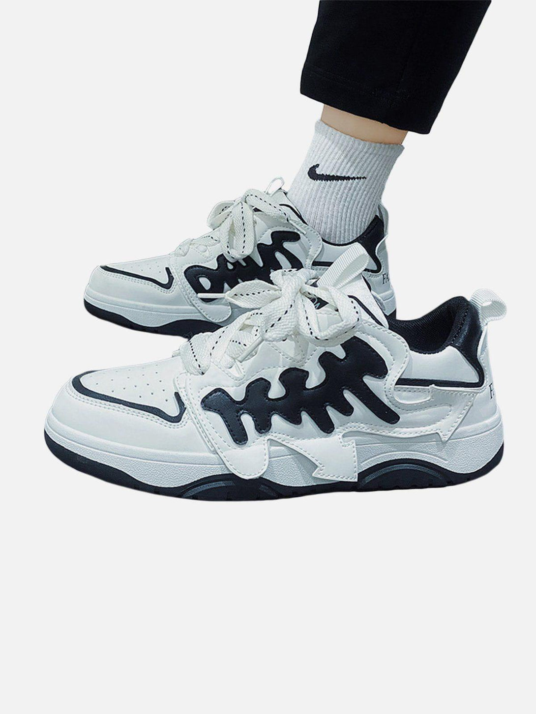 TALISHKO skate shoes in white with black accents, featuring a bold arrow pattern design.