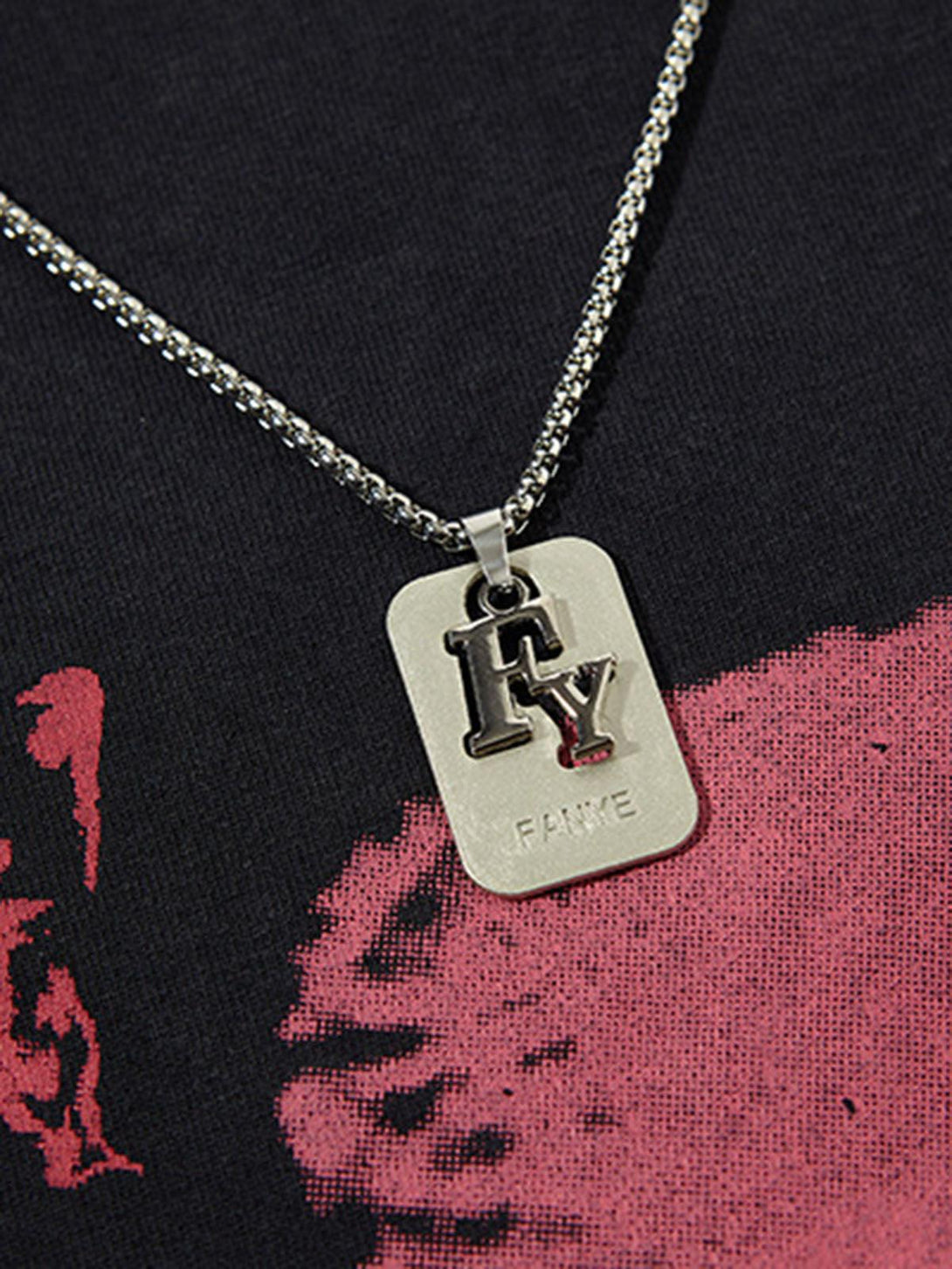 Chain necklace detail on a black and red graffiti vest by TALISHKO, showcasing unique style.