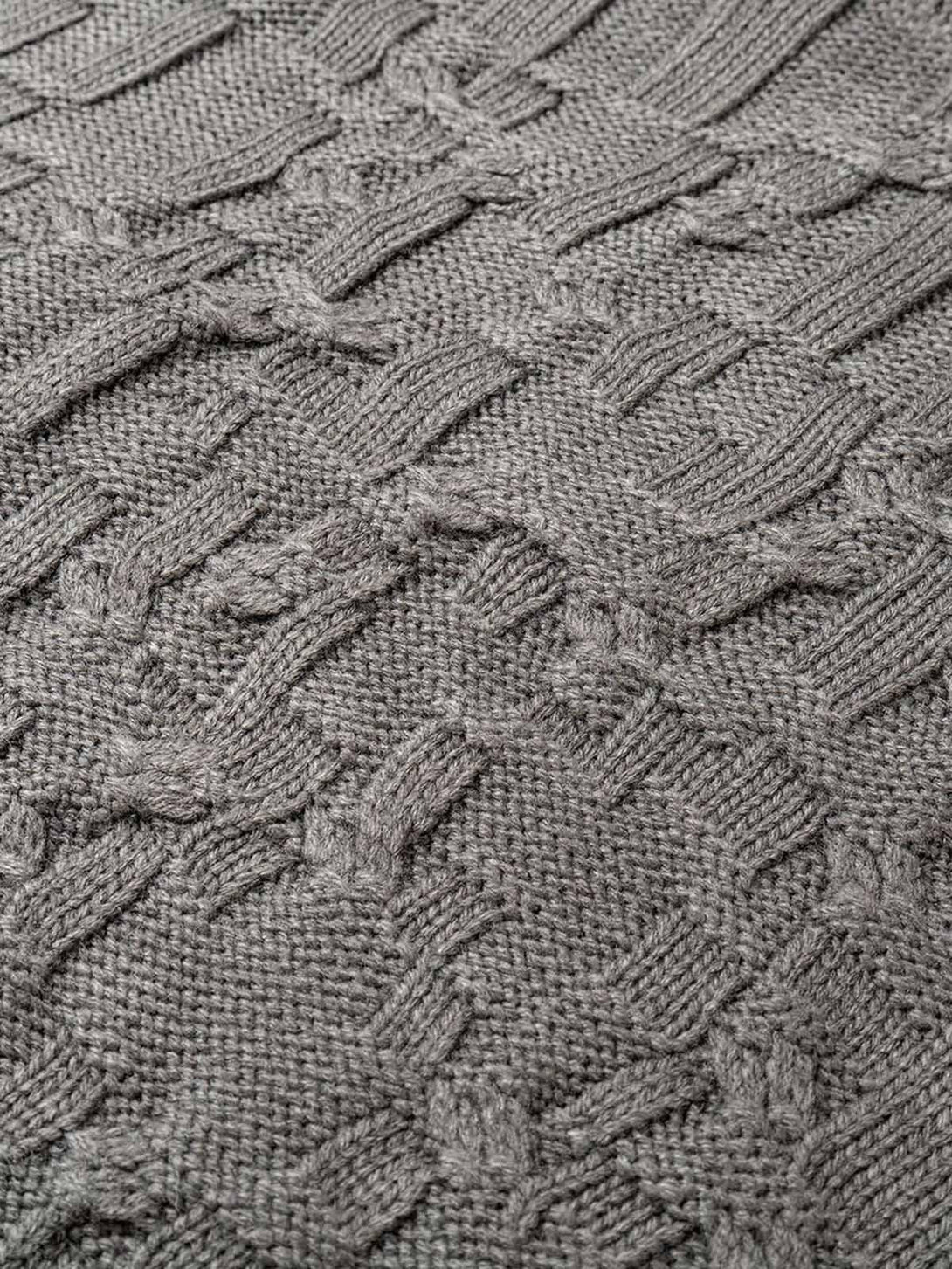 Texture and pattern showcased in the gray knitted sweater by TALISHKO, highlighting intricate design.