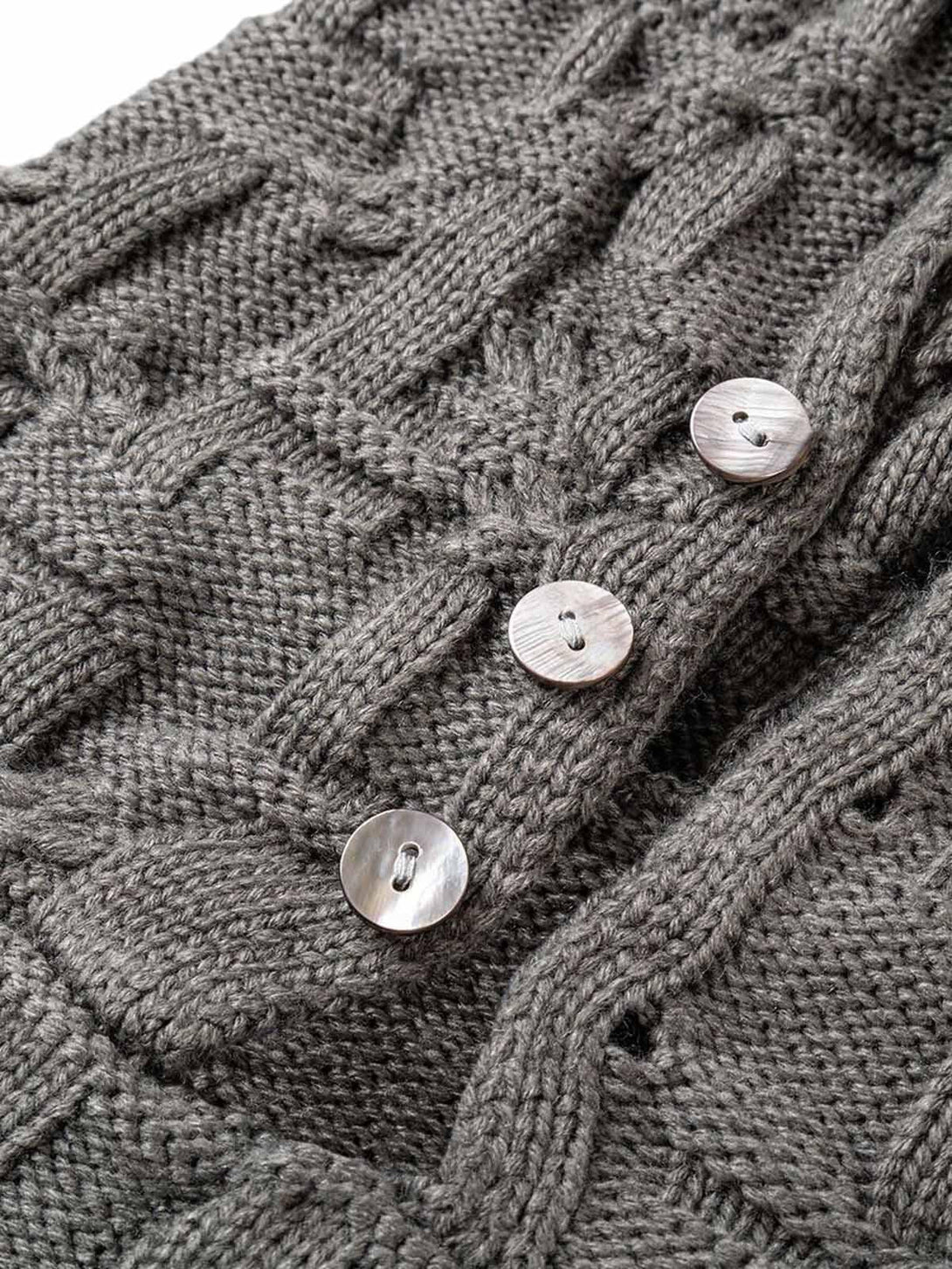Detailed fabric and stitching of the gray knitted sweater by TALISHKO, featuring unique buttons.